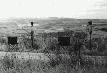 Two cameras on tripods and two empty seats